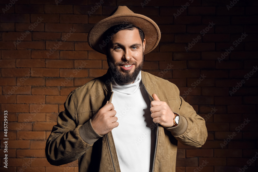 Stylish bearded man against brick wall