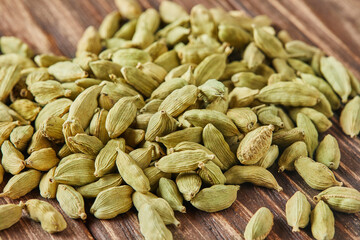 Sticker - Green cardamom is scattered over vintage wood background