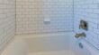 Panorama Alcove bathtub with white subway tile surround with black grout