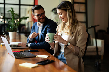 Wall Mural - Colleagues in office. Businesswoman and businessman discussing work in office.