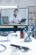© DC Studio - Empty hospital office with remote doctor having online medical discussion during telemedicine videocall meeting conference. Computer with telework videoconference call on screen. Medicine support