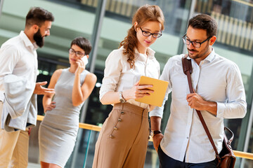 Canvas Print - Group of business people walking outside in front of office buildings.