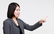 © Bangkok Click Studio - Portrait studio isolated cutout closeup shot of Asian young happy professional successful female businesswoman in formal suit jacket smiling look at camera holding hand pointing on white background