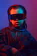 © saulich84 - portrait cyberpunk boy child in vr glasses in blue and red tones with wires on a red background