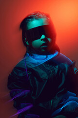 Wall Mural - blur portrait cyberpunk boy child in vr glasses in blue and red tones with wires on a red background