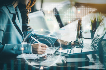 Financial planning and control concepts, women holding pen with notebook to calculate investment statements while using tablet computers to work, Using digital devices in data analysis.