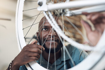 Aufkleber - Thats running just the way I like it. Shot of a handsome young man crouching alone in his shop and repairing a bicycle wheel.