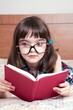 © gmstockstudio - Little girl reading a book at home