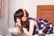 © gmstockstudio - Little girl using the laptop with earphones