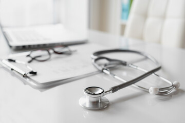 Doctor office desk, workplace of physician therapist with stethoscope closeup, Health care, medicine concept.