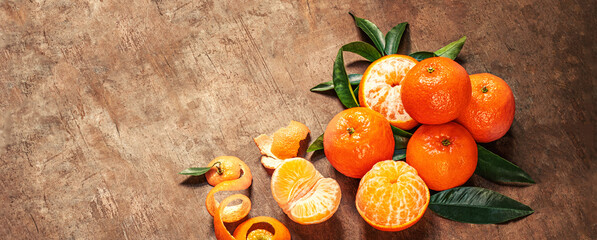 Wall Mural -  Mandarines oranges fruits or tangerines with green leaves on a wooden table. Copyspace. Fresh picked mandarins Top view..