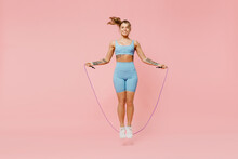Full Body Young Sporty Athletic Fitness Trainer Instructor Woman Wear Blue Tracksuit Spend Time In Home Gym Using Skipping Rope Isolated On Pastel Plain Light Pink Background. Workout Sport Concept.