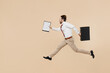 © ViDi Studio - Full body side view young employee business man corporate lawyer 20s in white shirt red tie glasses work in office jump run fast hold case contract document isolated on plain beige background studio