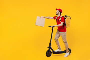 Wall Mural - Full body delivery employee man in red cap T-shirt uniform work as dealer courier ride kick scooter hold thermal food backpack brown blank craft paper takeaway bag isolated on plain yellow background.