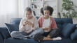 © Synthex - Positive African American friends chatting with friends, sitting on sofa at home