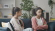 © Synthex - Sad teenage girls talking on couch, friends discussing problem, solving a conflict