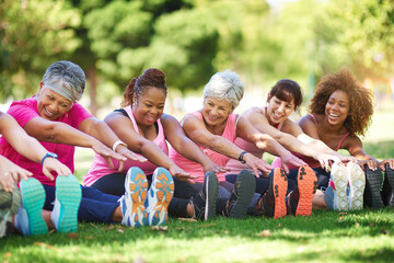 Poster - Having a laugh while limbering up. Shot of a group of people warming up outdoors.