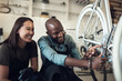 © Nicholas Felix/peopleimages.com - I fixed that. Shot of two young business owners crouching in their shop and fixing a bicycle wheel.