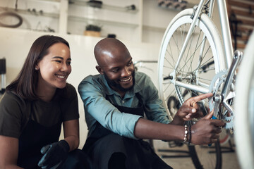 Aufkleber - I fixed that. Shot of two young business owners crouching in their shop and fixing a bicycle wheel.
