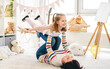 © Ievgen Skrypko - Laughing daughter flying on mother's legs in bright room