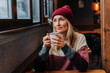 © Ilona - Apres ski, a woman in a coffee sitting in a cozy bar drinks coffee.