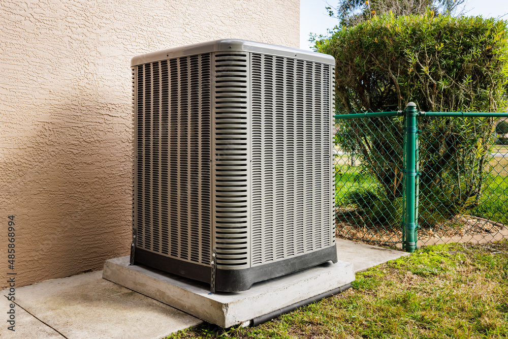 Modern HVAC air conditioner unit on concrete slab outside house. Stock ...