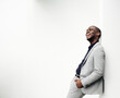 © mimagephotos - stylish african american businessman leaning against white wall and laughing