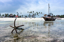 Anchor And Traditional Wooden Boat At Low Tide In Zanzibar, Tanzania