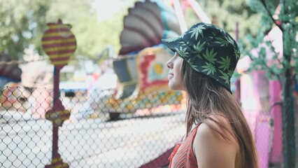 a girl looks at a working ride in a children's park.