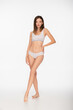 © LIGHTFIELD STUDIOS - full length view of young and slim woman in lingerie standing with hand on hip on white background