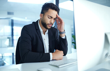 Poster - What a tough day its been. Shot of a young businessman experiencing a headache at his desk.