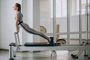 Wall Mural - Woman practising pilates in a pilates reformer