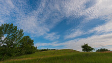 Meadow in hilly countryside and clouds.