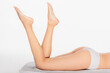© LIGHTFIELD STUDIOS - cropped view of barefoot woman in panties lying on towel on white background