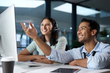 Teamwork makes the call work. Shot of a young man and woman using a computer while working in a call centre.