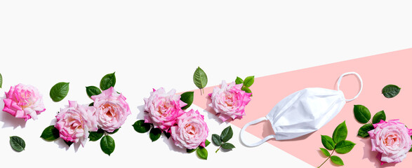 Wall Mural - Face mask with pink roses overhead view - flat lay