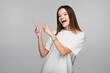 © LIGHTFIELD STUDIOS - thrilled woman pointing with fingers while looking at camera isolated on grey