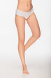 © LIGHTFIELD STUDIOS - cropped view of barefoot woman with smooth and slender legs on white background