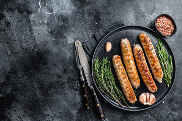 Wall Mural - Roasted Bockwurst pork meat sausages in a plate. Black background. Top view. Copy space