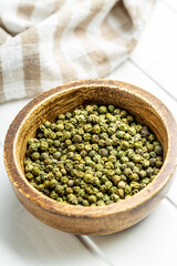 Canvas Print - Dried green peppercorn. Dry green pepper spice in bowl on white table.