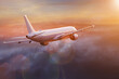 Passengers commercial airplane flying above clouds in sunset light. Concept of fast travel, holidays and business.