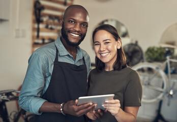 Aufkleber - Let us help you choose your bike. Shot of two young business owners standing together in their bicycle shop and using a digital tablet.
