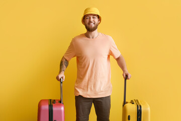 Sticker - Handsome young man with suitcases on yellow background