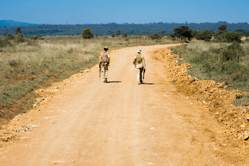 two heavily armed park rangers patrolling the dirt roads in nairobi national park, kenya, to protect