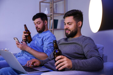 Sticker - Young brothers with bottles of beer relaxing at home in evening