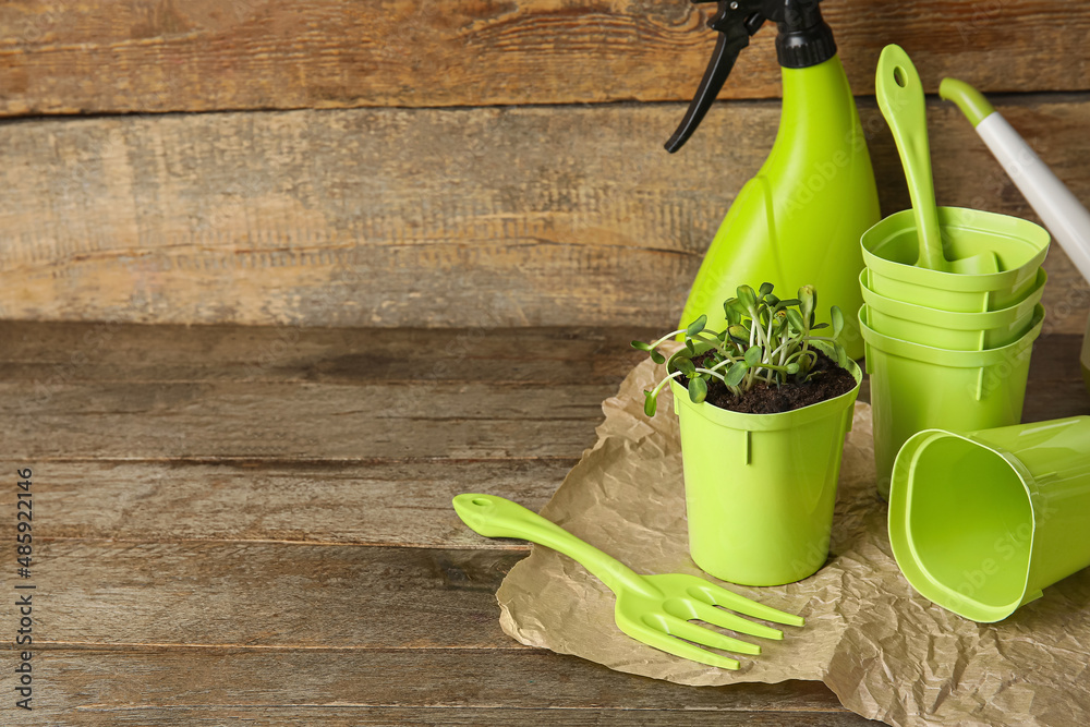 Composition with flower pots and gardening tools on wooden table, closeup