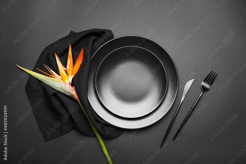 Simple table setting with bird of paradise flower on dark background