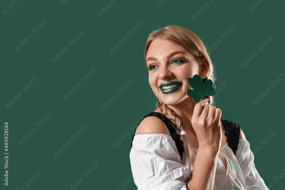 Beautiful Irish waitress with clover on green background. St. Patrick's Day celebration