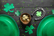 Leprechaun pot with golden coins, hats and horseshoe on dark wooden background. St. Patrick's Day celebration