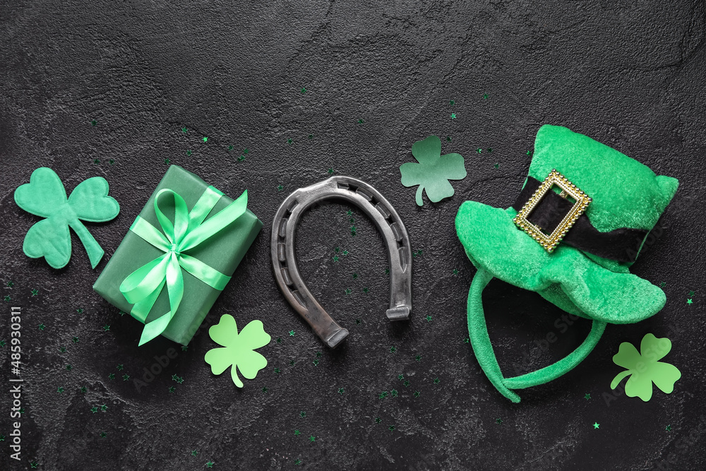 Leprechaun hat with gift and horseshoe on dark background. St. Patrick's Day celebration
